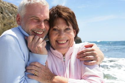 Mature couple hugging by the oceanside